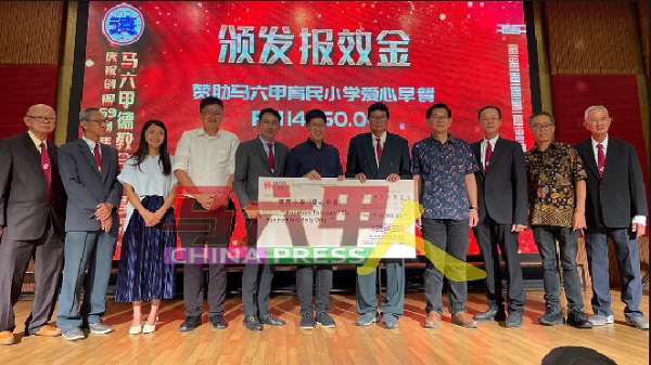 梁绍圣（左6）代表育民小学，接领1万4660令吉爱心早餐基金。