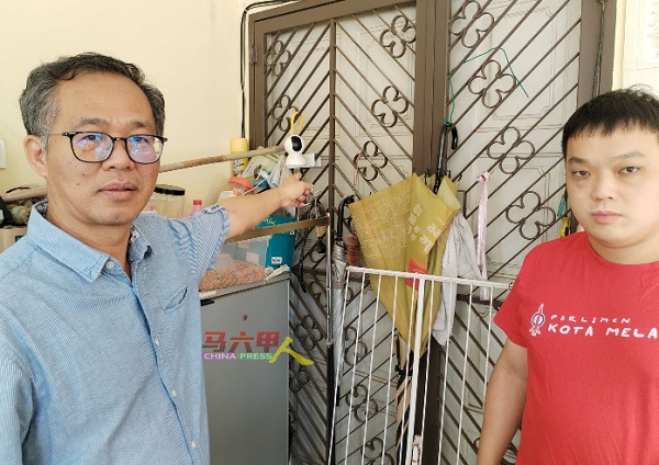 刘志俍（左起）与朱智威指着已被窃匪取走记忆卡的闭路电视。