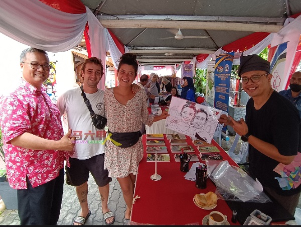 颜泳和（左起）与法国游客交流后，获悉后者对有关活动体现出马六甲的民间文化感到欣慰。