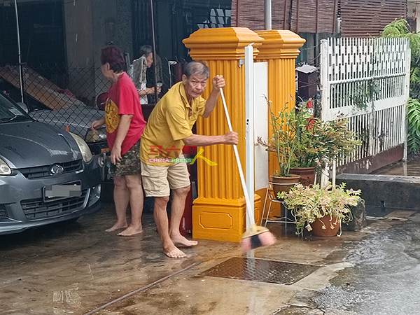 水灾消退后，民众赶紧清理住家范围。