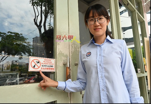 骆慧茹指着饮食店在门口处贴上“禁止宠物进入”告示牌。