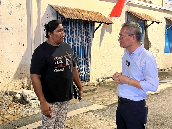 邱培栋（左）与当地居民交流，告诉恢复原状的好消息。