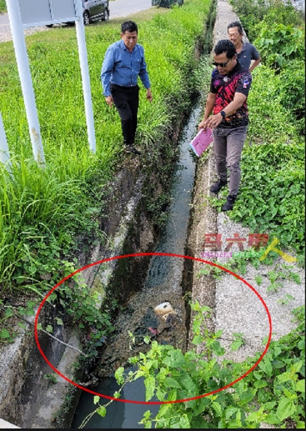 ■空地上方沟渠出现阻塞（红圈），左起为林千宏及胡赛尼，后为周开政。