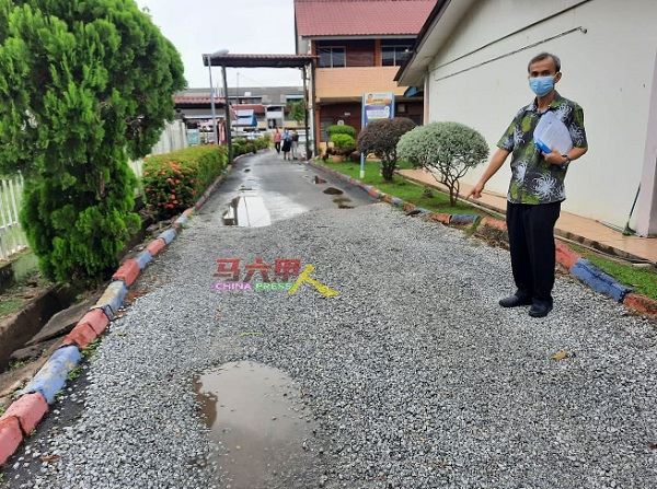 麦志坚指学校一些路段下雨时会积水，老师们自行以石子铺盖。