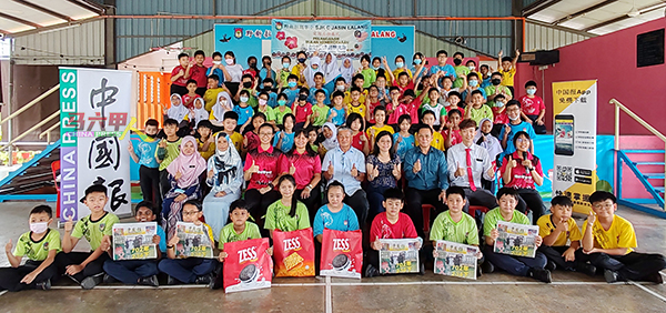 有奖问答得奖学生和受惠学生举起手中的《中国报》，与师长及嘉宾们合照。