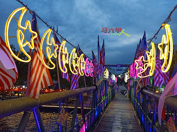 旧巴刹桥上挂有许多以国旗颜色为主的星月霓虹灯，景色灿烂。