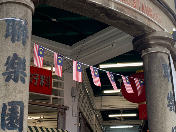建筑物和营业场所前悬挂着各种大小的国旗体现了社区欢庆国庆日的一面。