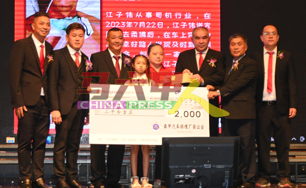 大会捐献2000令吉给江子伟家属；左起是王国华、陈志豪、熊源清，右起是赖汉明、刘国荣及钟国伟。