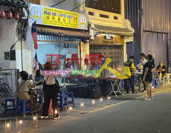 位于鸡场街的焕兴寿板店举行中元节祭拜仪式，场面热闹。