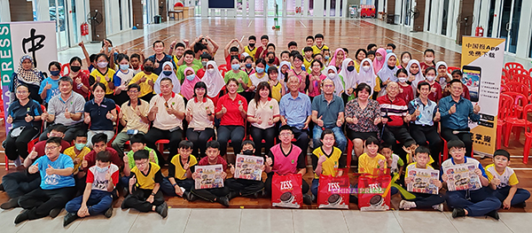 有奖问答得奖学生及受惠学生开心举起手中的《中国报》，与嘉宾师长们合照。