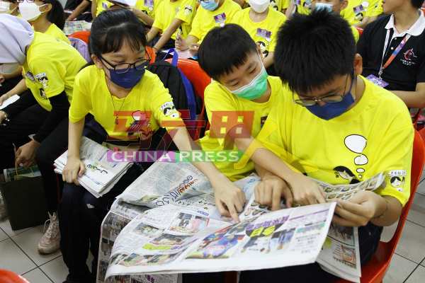 小记者们在活动开始前，阅读《中国报》刊登有关培 训营的新闻报导。