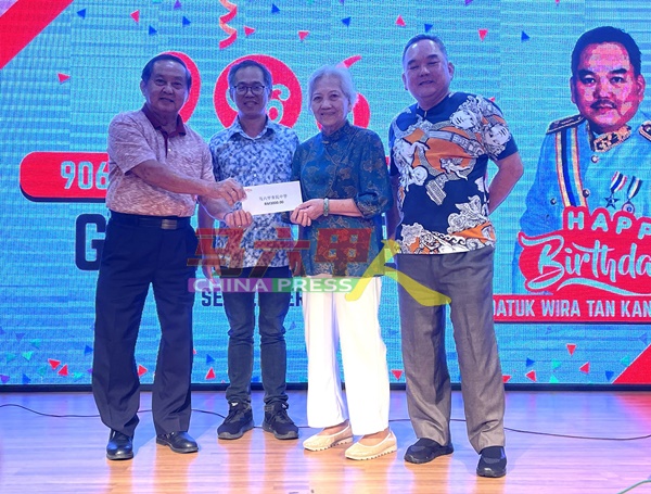 马六甲育民国民型中学董事长拿督颜贞强（左起）在刘志俍见证下，从陈妹及陈江荣手中接过善款。