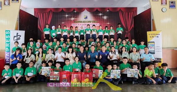 有奖问答得奖学生及受惠学生开心地举起手中的《中国报》，与嘉宾师长们合照。