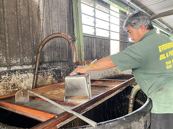 ■工作人员以人工手动方式，向回锅油进行最初阶段的去除沉淀物及杂物工作。