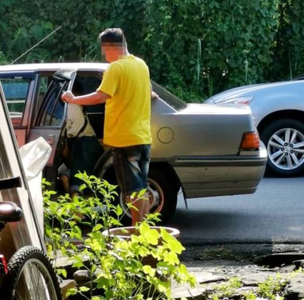 残障男登上一辆本地注册号码的轿车，由本地男子载走。