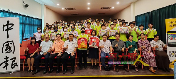 有奖问答得奖学生及受惠学生举起手中的《中国报》，与嘉宾们合照。