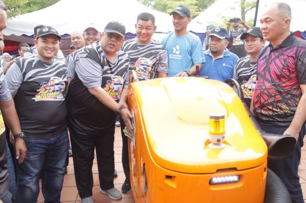 阿都拉勿（左2）为扫地机器人贴上“2024年甲州旅游年”宣传贴纸。前排左起为甲州高级行政议员拿督威拉莱斯雅欣、甲州行政议员拿督阿都拉萨及马六甲历史城市长拿督沙丹（右）。