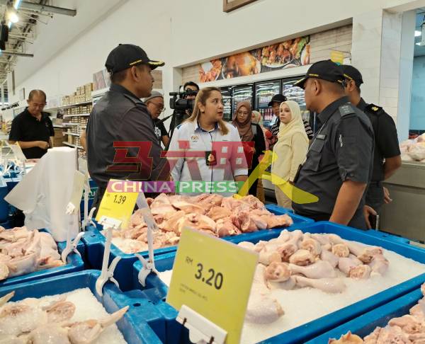 诺丽娜（中）随内贸局执法队到霸市检查肉鸡价格。