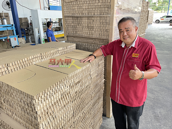 陈金顺向《中国报》展示“蜂窝”纸品制成的电子产品包装防撞物，能替代保丽龙，达到环保效果。