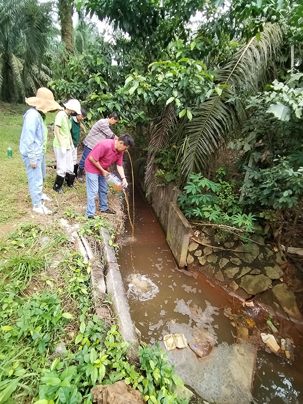 村民在志工的指导下，将环保酵素倒入河中。