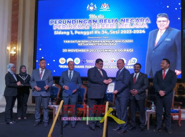 首长阿都拉勿（左5起）颁发马六甲青年组织委任证书给沙丹。