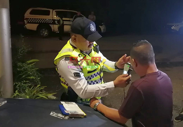 ■交警为一名怀疑醉驾的男子进行酒精测验。