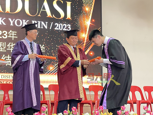 ■5牛顿班级毕业生，从颜贞强（左2）手中接过毕业证书；左为吴大鹏校长。