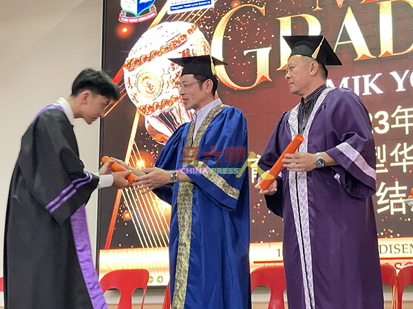 ■幸立雄（右起）陪同李献，颁发毕业证书给中五毕业生。