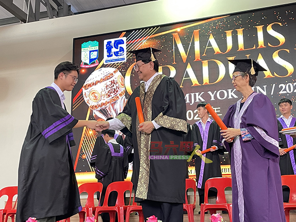 ■林朝盛（右2）在汪玉珠（右）陪同下，移交毕业证书给毕业生。