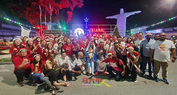 参与“怡力选区圣诞报佳音”活动成员在巨型耶稣塑像前拍照。