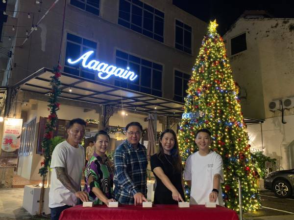 颜天禄（中）为Aaagain咖啡馆配合圣诞节所打造户外巨型的圣诞树主持亮灯仪式。左起为伍雀祥、黄家容、伍艳妮、伍艳晶。
