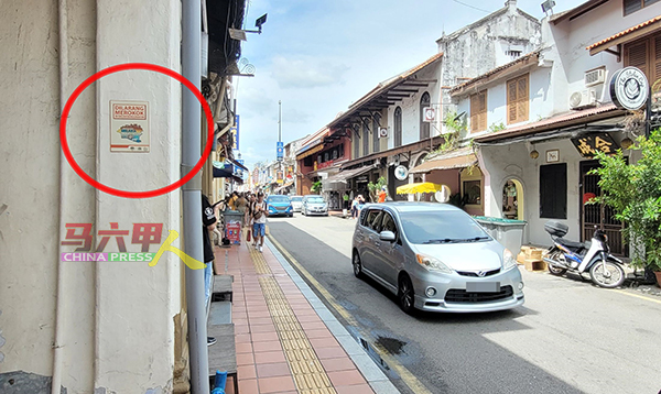 设于鸡场街店屋前的禁止吸烟告示牌（红圈）小且不明显，很难获得游客注意。