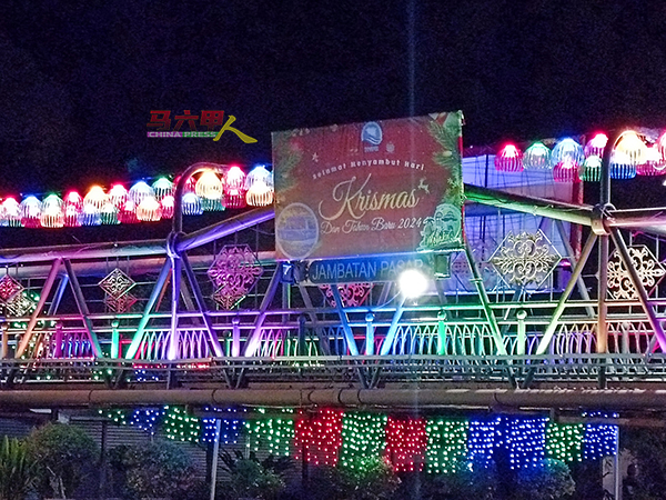 桥中央还挂有写有欢庆圣诞节和2024新年快乐的横幅，为过往行人带来温馨的祝福。