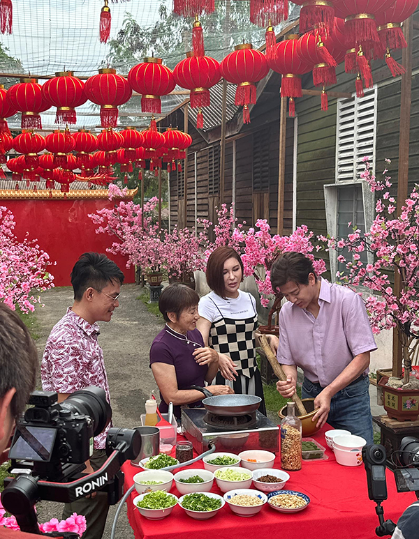 陈晓东（右起）及利菁与村民互动，体验煮擂茶的乐趣。