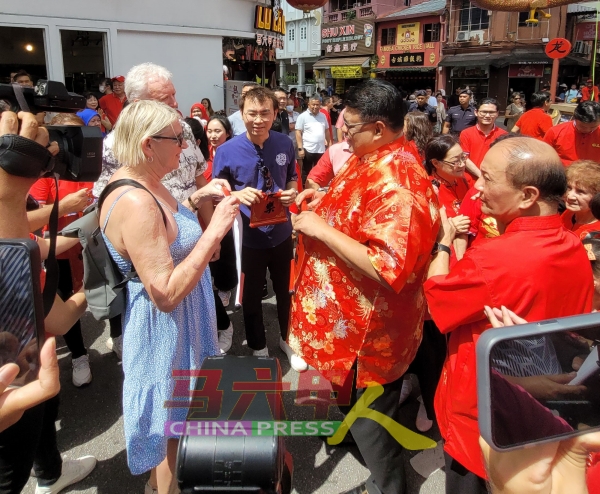 首长（右2）在鸡场街与国外游客交流，了解游客对古城的看法。
