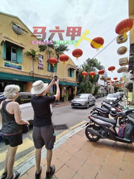 外国游客对大红灯笼所吸引，拍照留念。