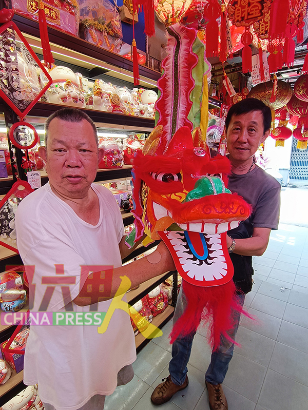 黄良成（左起）向李兴季推介舞龙玩具，为龙年最夯的传统玩具。