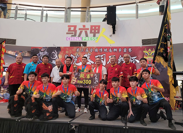 殿军得主峇株金凤山宮龙狮团接领奖杯。