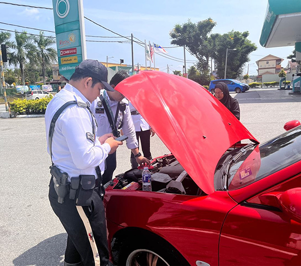 交警协助民众把抛锚汽车推至附近油站。