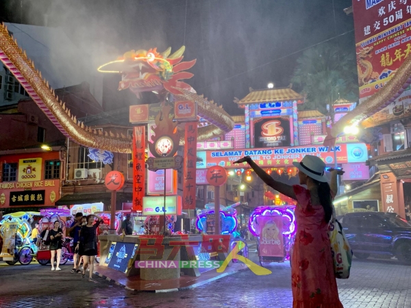 祥龙吐水时，一名女游客在“雨中”手舞足蹈，十分享受。