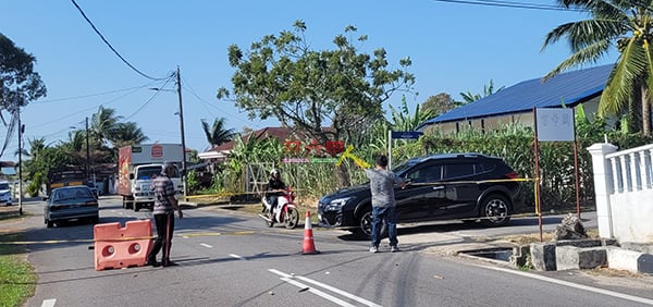 车辆暂时只能使用民众会堂旁小路来往，林佑福（右）及一名警员在路口前指挥交通。