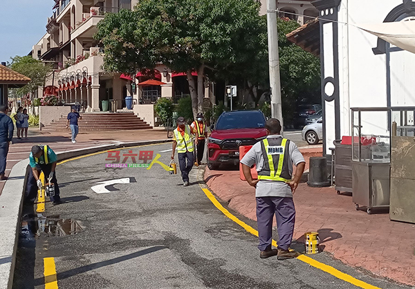 ■市政厅派员在哥打拉沙马那巷画上黄线和路面箭头，提醒道路使用者。