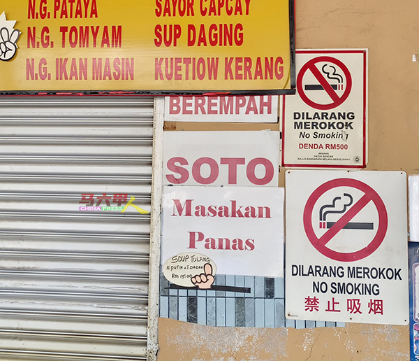 商家在摊档旁贴上禁止吸烟的告示牌，以提醒烟民，避免遭取缔。
