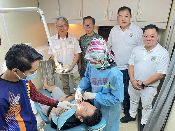 政府牙医诊所团队设流动式柜枱，为民众进行免费口腔检查。后排右起为曾添兴、陈再政、刘志俍及陈金锡。