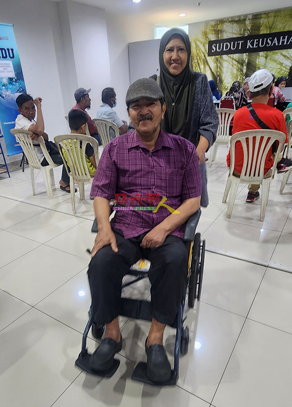 法丽达罗哈尼推着坐轮椅的莫哈末拉祖旺，完成注册PADU。