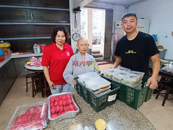 洪玉娟（左）与团友将准备好的素食送到青云亭，由释理行接领（中）。