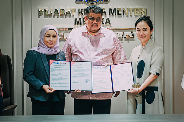 西蒂艾因莎（左）及葛雅镁（右）在阿都拉勿见证下，完成芒果传媒有限公司及马六甲控股机构合作签约仪式。