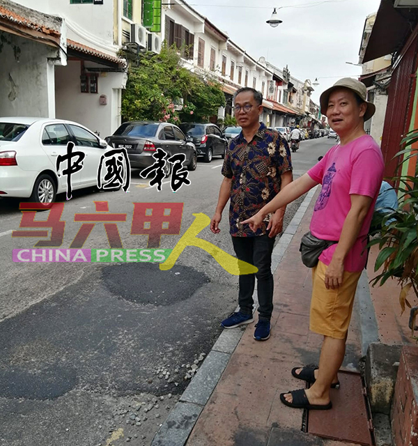 陈益龙（右起）向刘志俍反映荷兰街铺了又破损的路面。