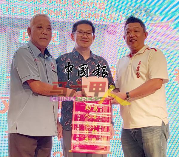 明星慈善社总务冯利兴（左）接领500令吉义款。