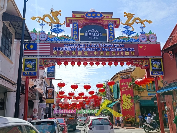靠近地理学家餐厅的鸡场街年景牌楼，除了展示马中建交50周年纪念外，也印有马来西亚及中国国旗。